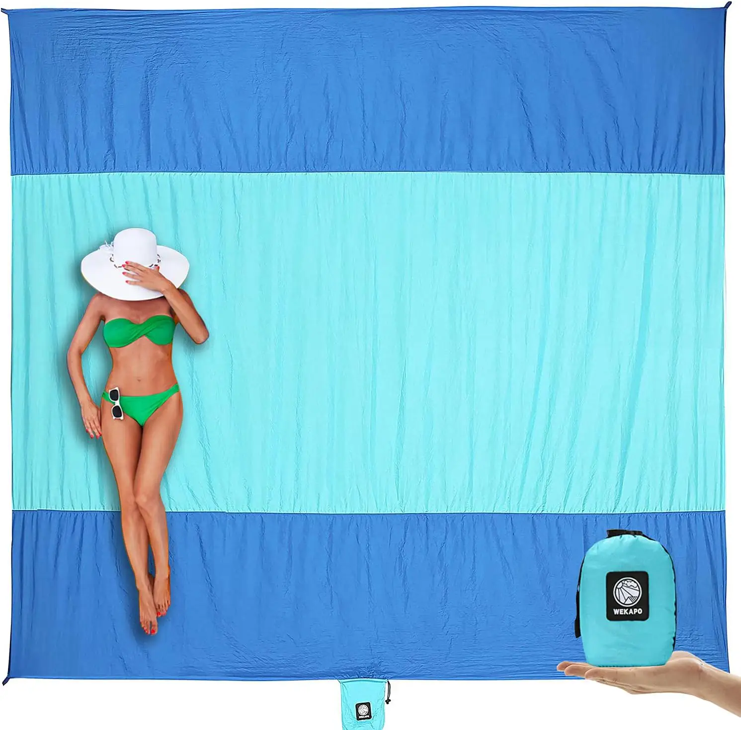 Woman in a bikini and hat laying on top of a blue and white beach towel