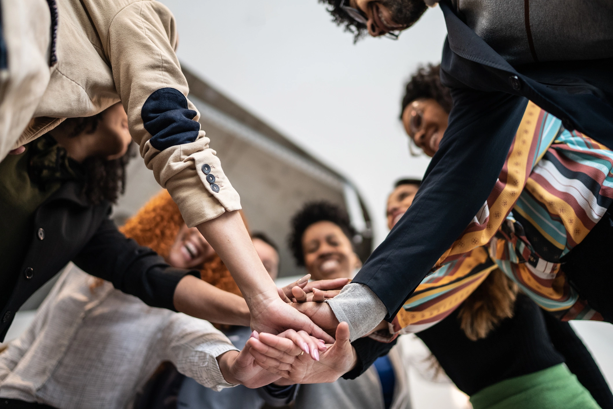 Group of people standing in a circle, their hands joined together in a show of unity and solidarity